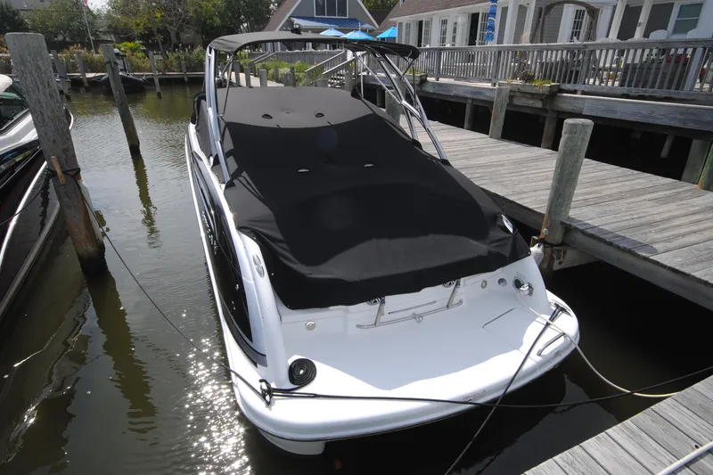 Slide: The Image of 2015 Formula 310 Bowrider docked with black cover, surrounded by wooden piers. - 2
