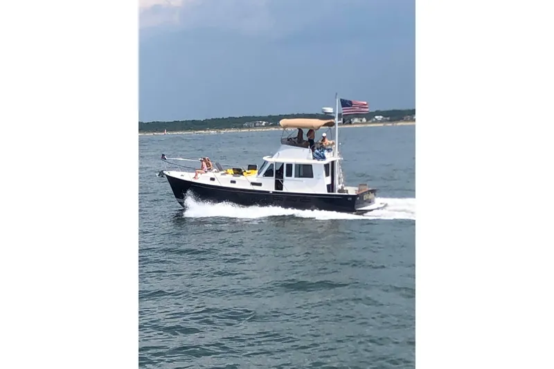 The Image of 1999 Legacy Yachts 40 Sedan cruising on open water with passengers onboard. - 0