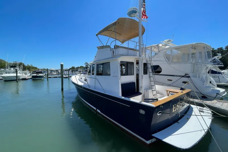 Slide: The Image of 1999 Legacy Yachts 40 Sedan docked at a marina under clear blue skies. - 101