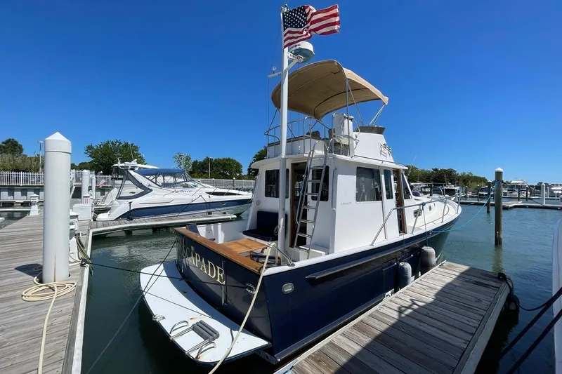 Slide: The Image of 1999 Legacy Yachts 40 Sedan docked at marina under clear blue sky. - 102