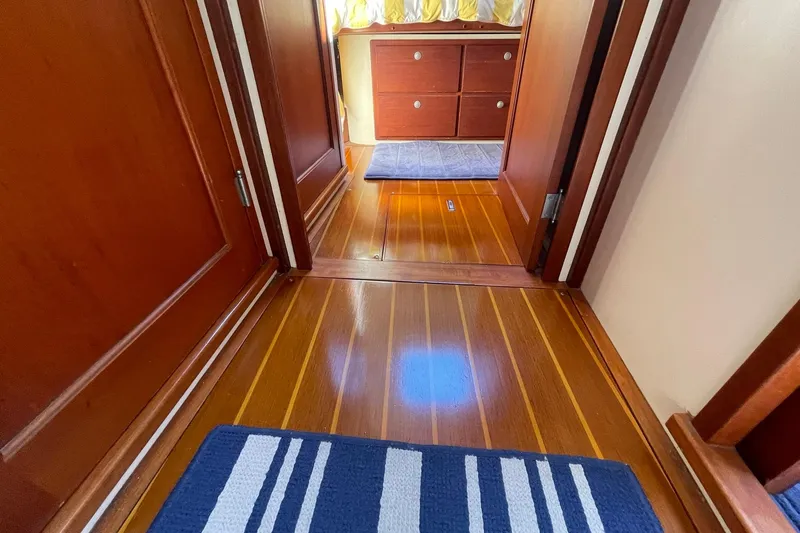 Slide: The Image of 1999 Legacy Yachts 40 Sedan docked, rear view with American flag, clear sky. - 105