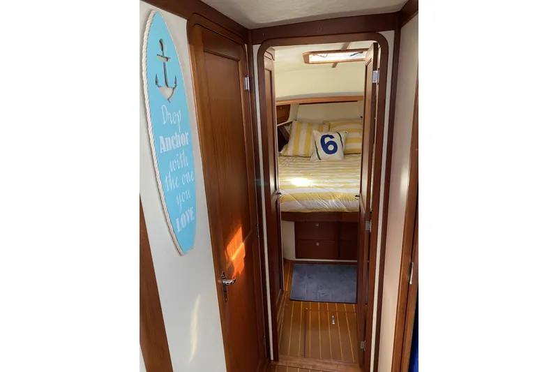 Slide: The Image of 1999 Legacy Yachts 40 Sedan interior with cozy bedroom and nautical decor. - 11