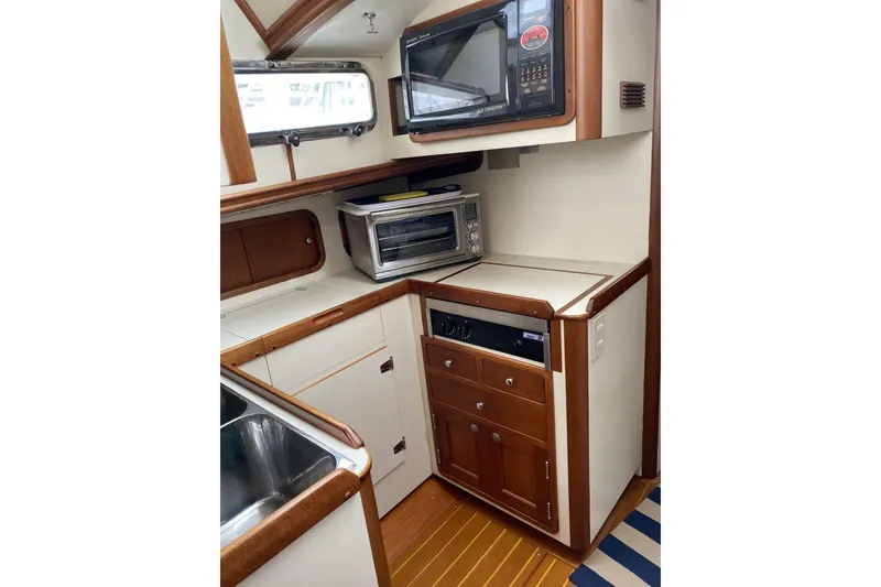 Slide: The Image of 1999 Legacy Yachts 40 Sedan galley with microwave, toaster oven, and wooden cabinetry. - 15