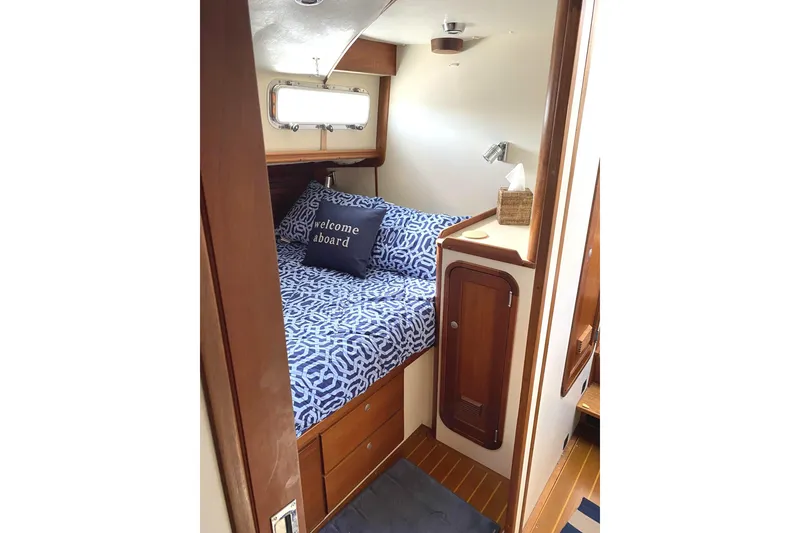 Slide: The Image of 1999 Legacy Yachts 40 Sedan cabin with cozy bed and nautical decor. - 17