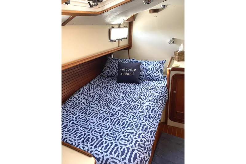 Slide: The Image of Cozy cabin interior of 1999 Legacy Yachts 40 Sedan with patterned bedding and welcome pillow. - 18