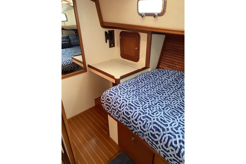 Slide: The Image of 1999 Legacy Yachts 40 Sedan cabin with patterned bedding and wooden interior. - 19