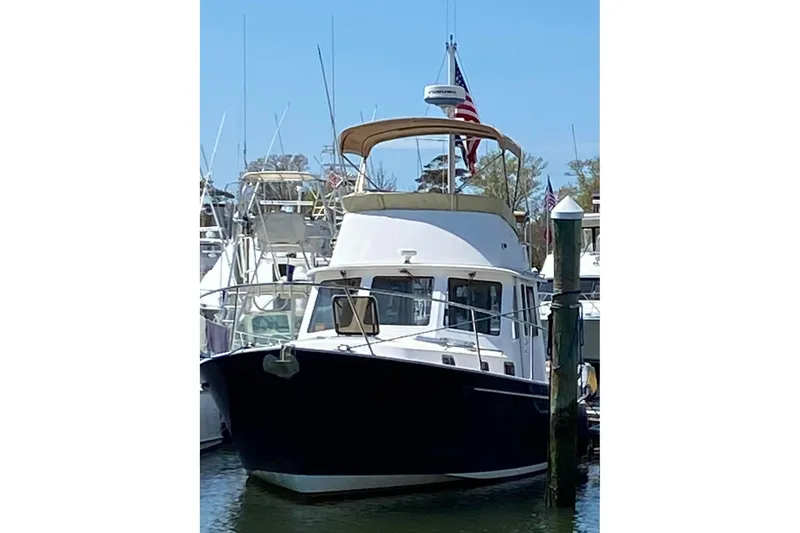 Slide: The Image of 1999 Legacy Yachts 40 Sedan docked at marina, featuring classic design and American flag. - 2