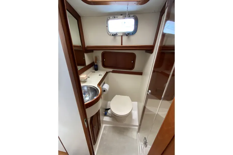 Slide: The Image of 1999 Legacy Yachts 40 Sedan bathroom with sink, toilet, and wooden accents. - 20