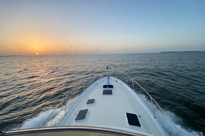 Slide: The Image of 1999 Legacy Yachts 40 Sedan cruising at sunset on open water. - 24