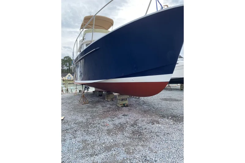 Slide: The Image of 1999 Legacy Yachts 40 Sedan with blue hull on dry dock, side view. - 29