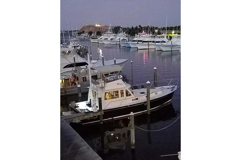 Slide: The Image of 1999 Legacy Yachts 40 Sedan docked at a marina during twilight. - 33