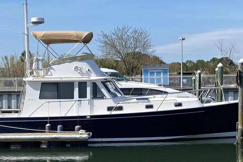 Slide: The Image of 1999 Legacy Yachts 40 Sedan docked at marina, featuring classic design and blue hull. - 35