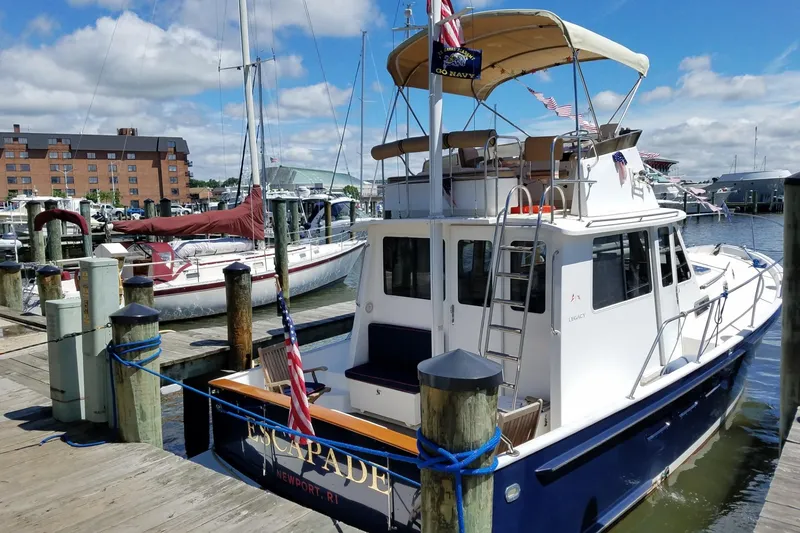 Slide: The Image of 1999 Legacy Yachts 40 Sedan docked at marina, sunny day, blue sky, flags displayed. - 36