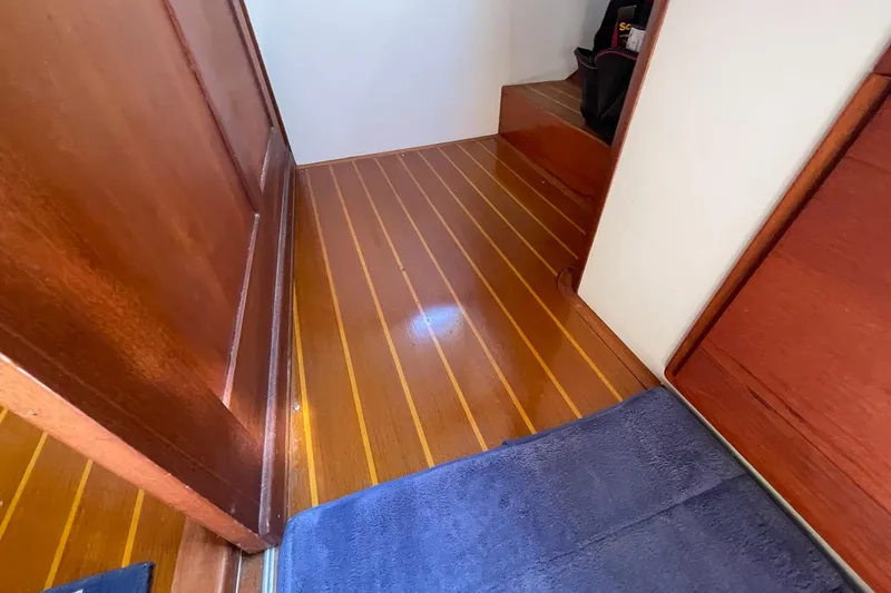 Slide: The Image of Polished wooden floor inside 1999 Legacy Yachts 40 Sedan, featuring rich wood paneling. - 38