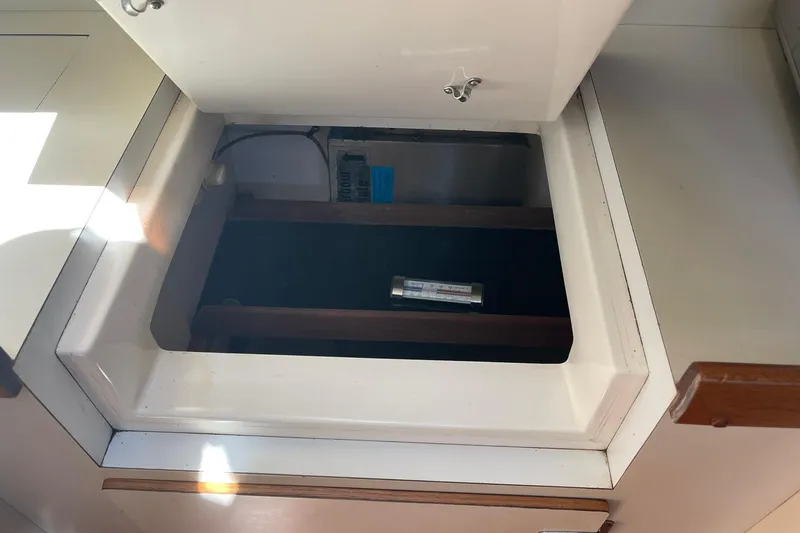 Slide: The Image of Open storage compartment on 1999 Legacy Yachts 40 Sedan, featuring wooden interior and visible thermometer. - 43