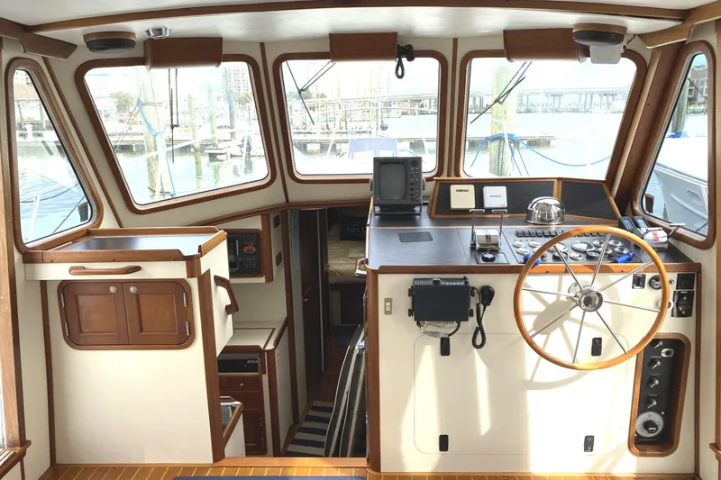 Slide: The Image of 1999 Legacy Yachts 40 Sedan interior helm with wooden accents and navigation equipment. - 5