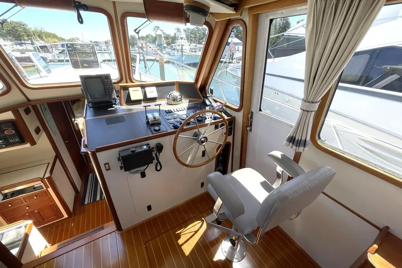 Slide: The Image of 1999 Legacy Yachts 40 Sedan helm with steering wheel, navigation equipment, and captain's chair. - 52