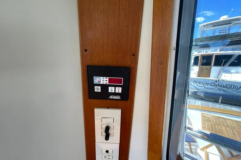 Slide: The Image of Control panel on 1999 Legacy Yachts 40 Sedan, with marina view through window. - 56