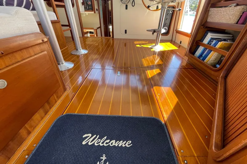 Slide: The Image of Interior of 1999 Legacy Yachts 40 Sedan with polished wooden flooring and welcome mat. - 61