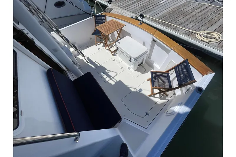Slide: The Image of 1999 Legacy Yachts 40 Sedan deck with chairs and table at dock. - 63