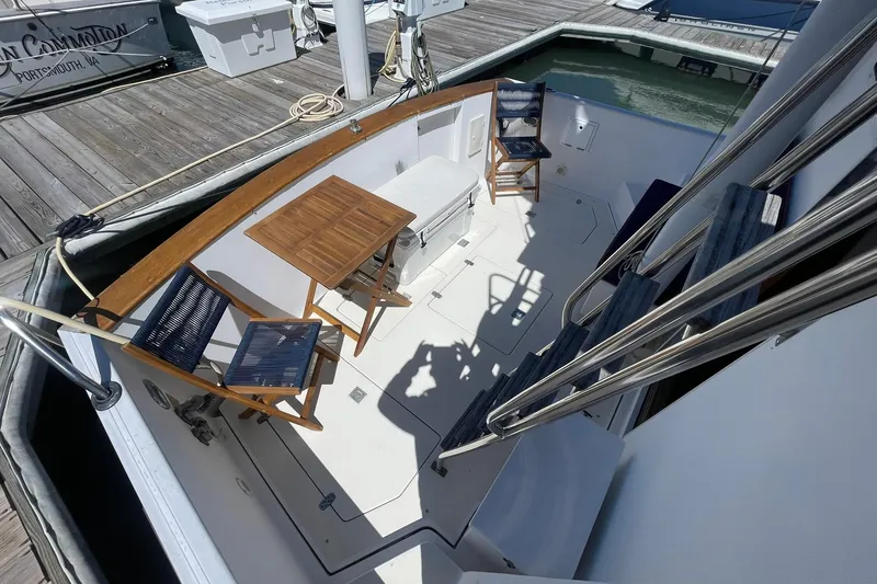 Slide: The Image of 1999 Legacy Yachts 40 Sedan deck with chairs and table at dockside. - 64