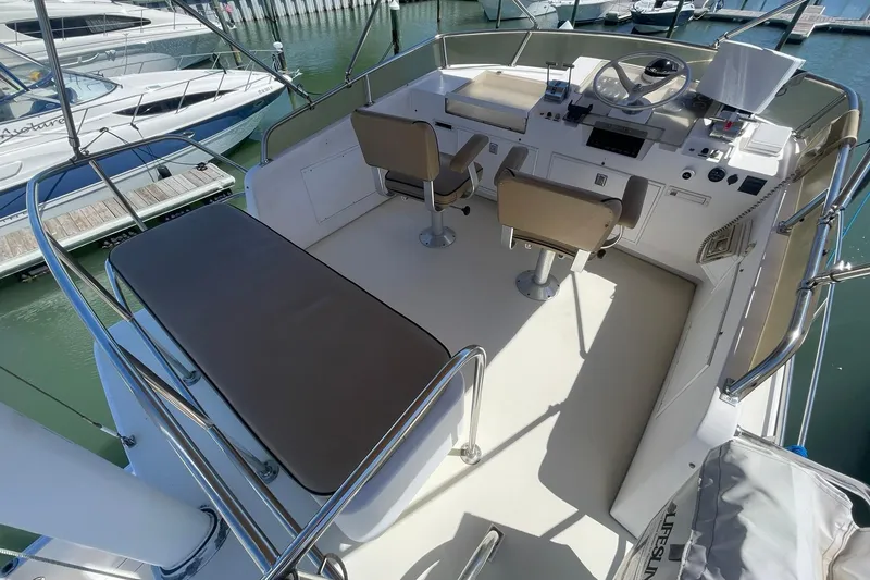 Slide: The Image of Flybridge of 1999 Legacy Yachts 40 Sedan with helm and seating, docked at marina. - 66