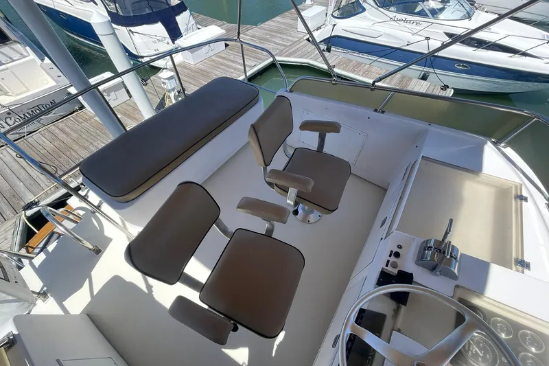 Slide: The Image of Cockpit of 1999 Legacy Yachts 40 Sedan with helm and seating, docked at marina. - 67