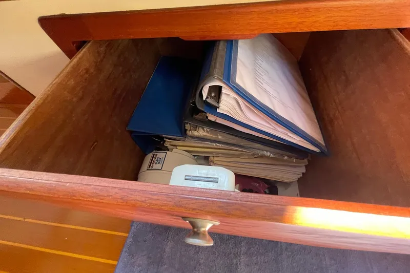 Slide: The Image of Open wooden drawer with documents and binders, aboard a 1999 Legacy Yachts 40 Sedan. - 74
