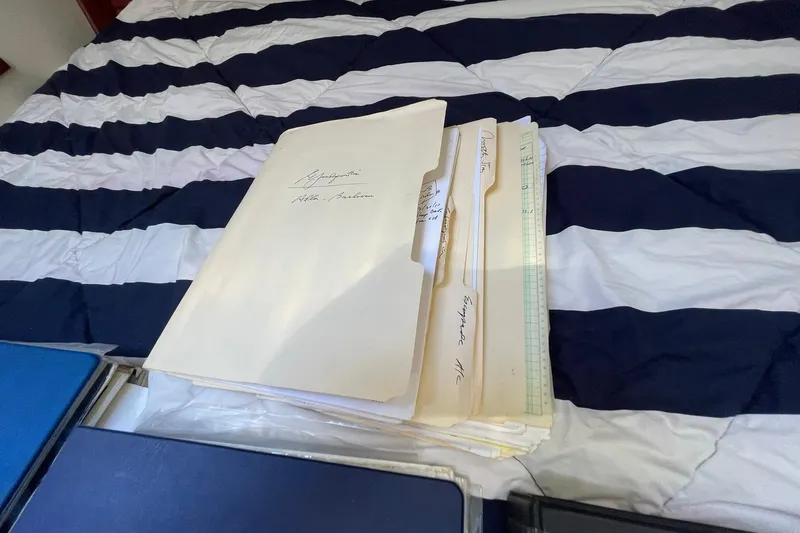 Slide: The Image of Folders on a striped bed inside a 1999 Legacy Yachts 40 Sedan. - 79