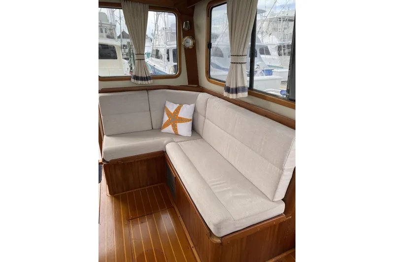 Slide: The Image of Interior of 1999 Legacy Yachts 40 Sedan with cushioned seating and starfish pillow. - 8