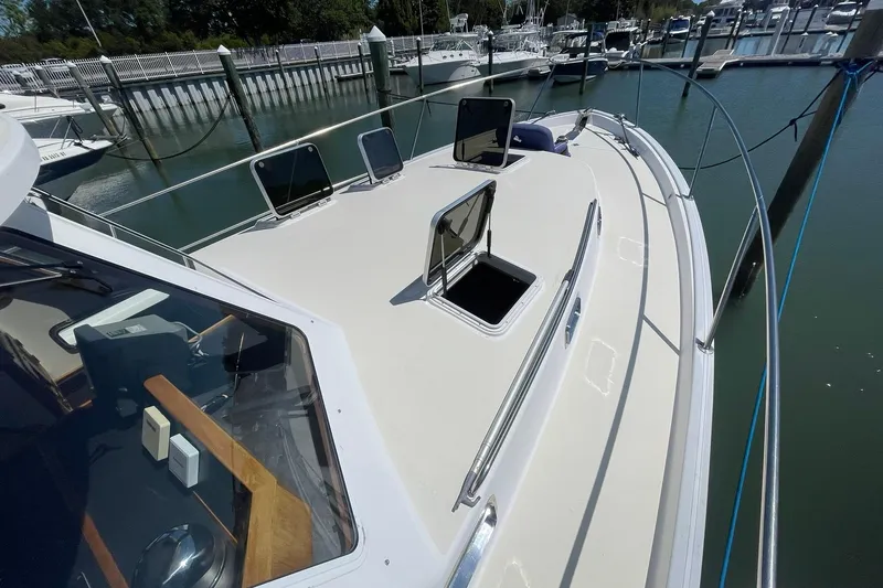 Slide: The Image of 1999 Legacy Yachts 40 Sedan docked, showcasing open hatches and sleek deck design. - 83