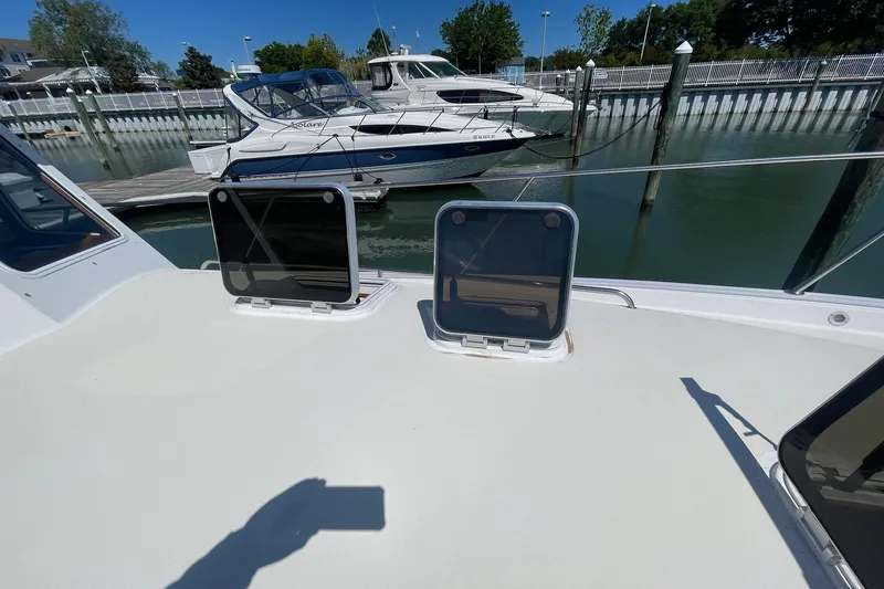 Slide: The Image of 1999 Legacy Yachts 40 Sedan docked, featuring open hatches and nearby boats. - 85