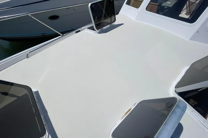 Slide: The Image of 1999 Legacy Yachts 40 Sedan deck with open hatches and sleek design. - 86
