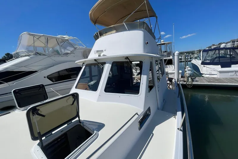 Slide: The Image of 1999 Legacy Yachts 40 Sedan docked at marina under clear blue sky. - 88