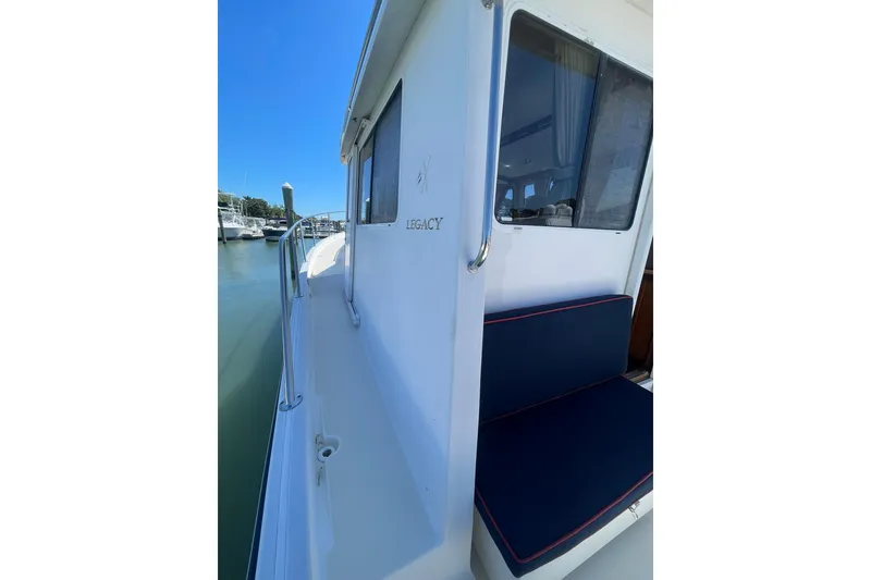Slide: The Image of 1999 Legacy Yachts 40 Sedan, side view with blue seating, docked in marina. - 91