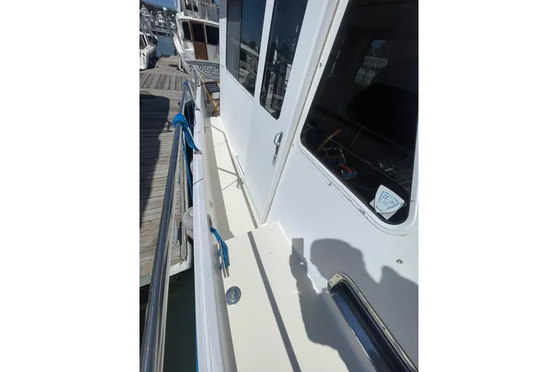Slide: The Image of 1999 Legacy Yachts 40 Sedan docked, showcasing side deck and railing details. - 92