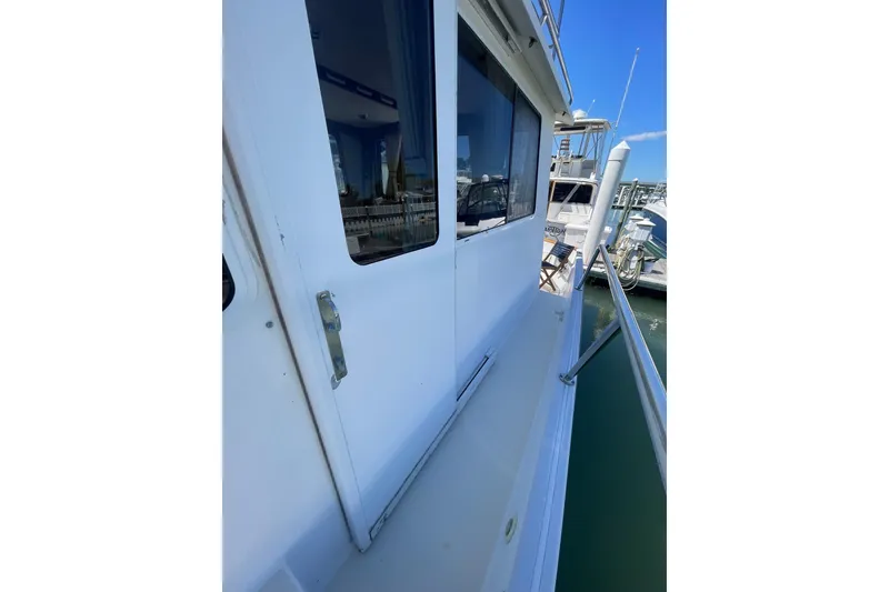 Slide: The Image of Side view of 1999 Legacy Yachts 40 Sedan docked at marina. - 93