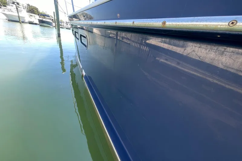 Slide: The Image of Side view of a 1999 Legacy Yachts 40 Sedan docked in calm waters. - 94