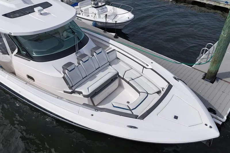 Slide: The Image of 2021 Tiara Sport 43 LS luxury boat docked, featuring sleek design and spacious seating. - 15