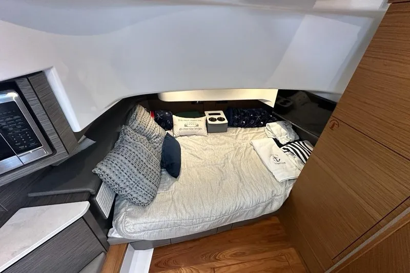 Slide: The Image of 2021 Tiara Sport 43 LS cabin interior with cozy bedding and modern design elements. - 29