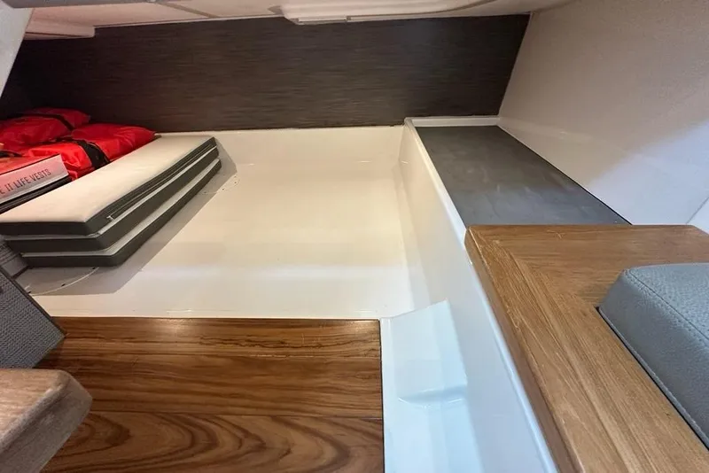 Slide: The Image of 2021 Tiara Sport 43 LS interior cabin with life vests and wooden flooring. - 35