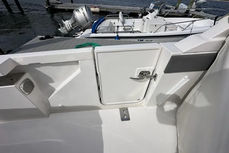Slide: The Image of 2021 Tiara Sport 43 LS boat deck with open hatch and docked motorboat. - 38