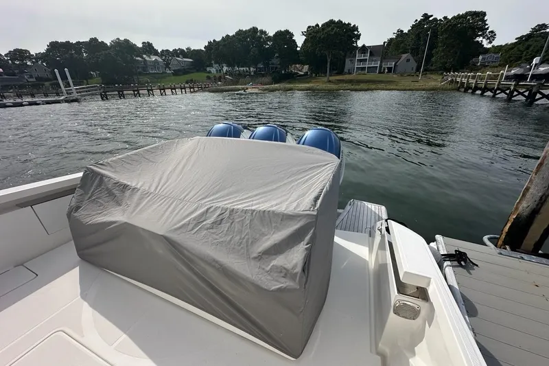 Slide: The Image of 2021 Tiara Sport 43 LS boat with covered engines docked by a scenic waterfront. - 41