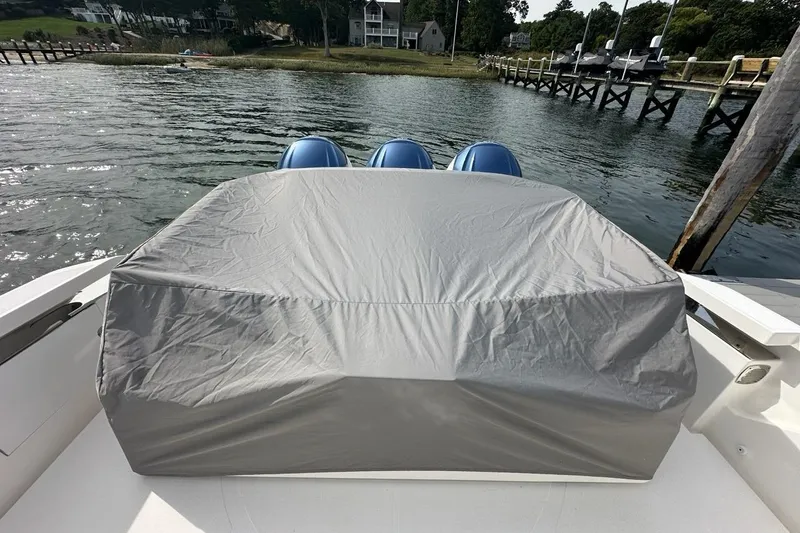 Slide: The Image of 2021 Tiara Sport 43 LS boat with covered engines, docked by a scenic waterfront. - 42