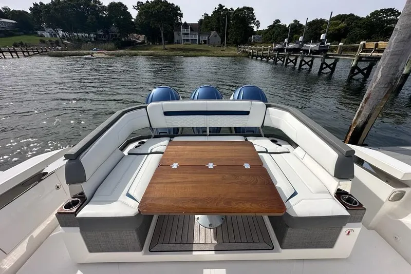 Slide: The Image of Luxury seating area on a 2021 Tiara Sport 43 LS boat with wooden table. - 44