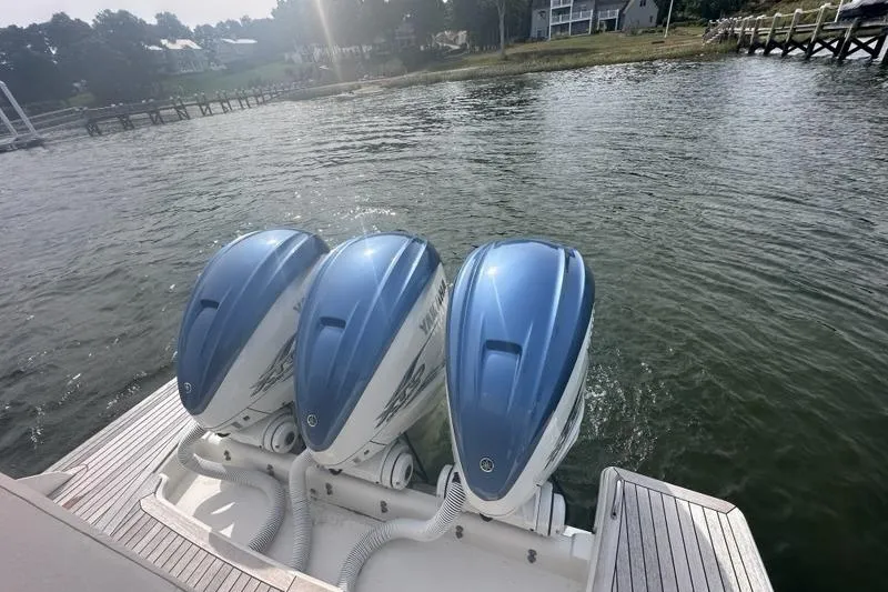 Slide: The Image of Triple Yamaha outboard engines on a 2021 Tiara Sport 43 LS boat by the water. - 71