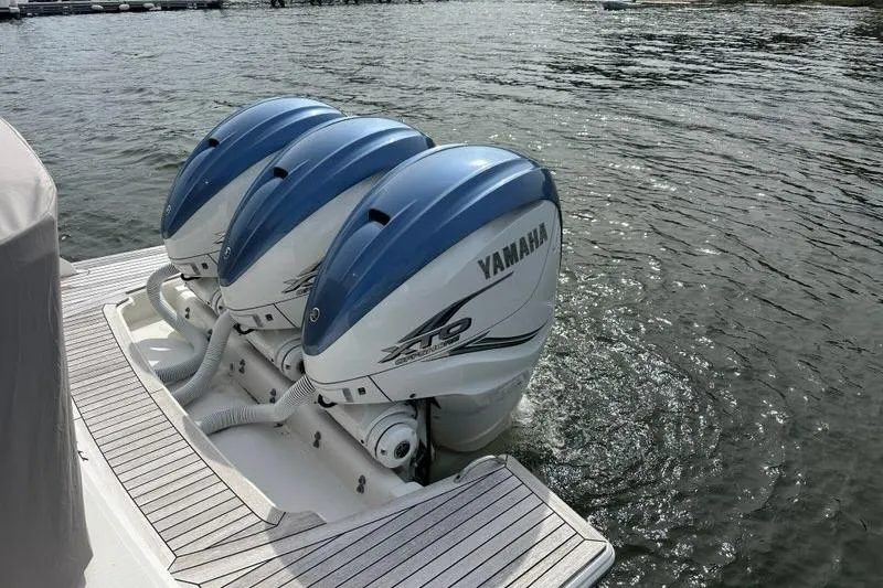 Slide: The Image of Triple Yamaha outboard engines on a 2021 Tiara Sport 43 LS boat, docked on water. - 72