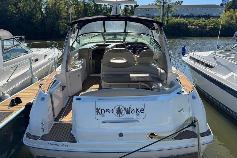 Slide: The Image of 2000 Sea Ray 380 Sundancer docked, featuring spacious seating and "Knot Wake" sign. - 5