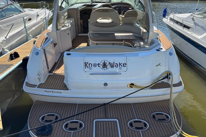 Slide: The Image of Sea Ray 380 Sundancer 2000 docked, featuring teak deck and "Knot Wake" nameplate. - 6