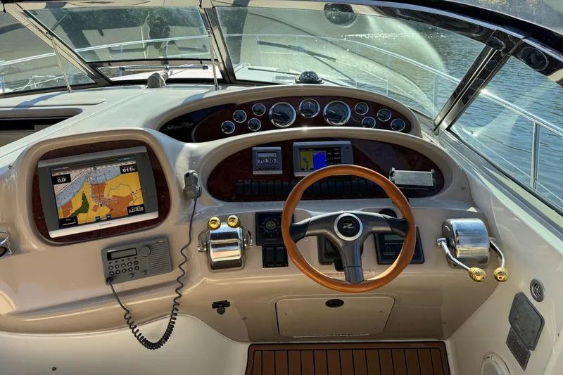 Slide: The Image of Cockpit of 2000 Sea Ray 380 Sundancer with navigation equipment and wooden steering wheel. - 8